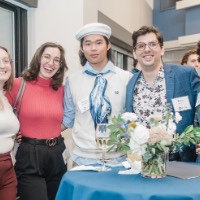 5 GVSU Alumni posed for camera and stand around a table